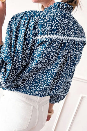 Peacock blue medallion print poet blouse with ruffled collar and white trim detail.