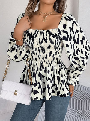 Cream and black leopard print smocked bodice square neck peplum blouse with ruffled cuffs.