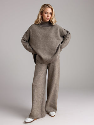 Oversized turtleneck lounge knit set in taupe acrylic with wide leg pants and relaxed fit sweater.