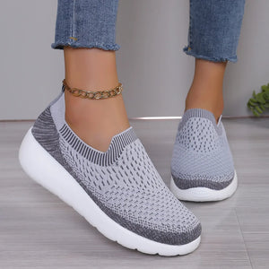 Light gray knit slip-on sneakers with sculpted white sole and textured pattern.