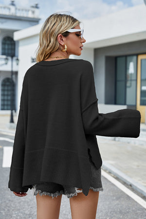 Black acrylic knit sweater with flared sleeves and split hem detail