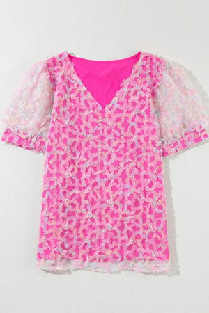 Fuchsia pink blouse with floral appliqué mesh puff sleeves and V-neck.