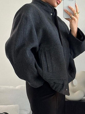 Dark Gray bouclé cocoon jacket with snap closure and textured pockets.