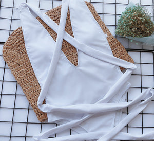 White wrap-around halterneck plunge swimsuit with crisscross back ties.