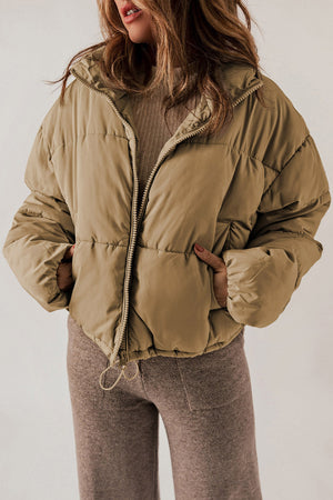 Taupe cropped puffer jacket with hood, zipper front, and drawstring hem.
