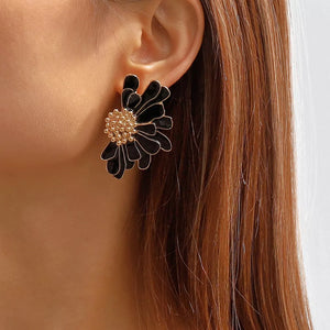 Textured black flower stud earrings with gold center detail.