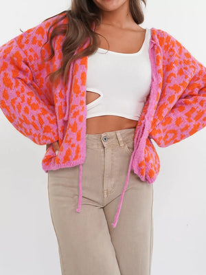 Vibrant leopard print tie-front cropped cardigan in pink and orange with balloon sleeves.