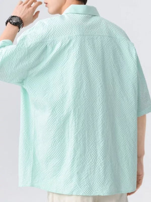 Men's mint green short-sleeve shirt with textured fabric and buttoned collar.