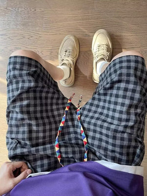 Men's gray and black plaid drawstring shorts with colorful tie detail
