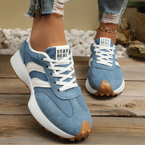 Sky blue lace up round toe sneakers with white stripes and a chunky sole.