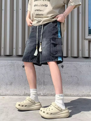 Black denim cargo shorts with braided drawstring and tassel details.