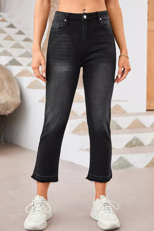 Maternity jeans in charcoal wash denim with distressed raw hem and cropped length.