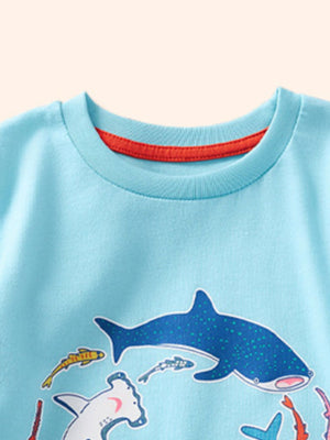 Baby blue cotton t-shirt with playful shark and fish print, crew neck with red trim.