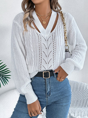 White cable knit sweater with V-neck cutout detail and open knit pattern.