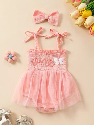 Pink smocked baby bodysuit with tulle skirt and matching bow headband.