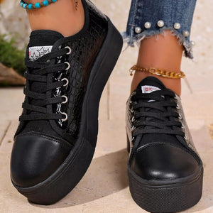 Black crocodile embossed platform sneakers with a chunky sole and lace-up closure.
