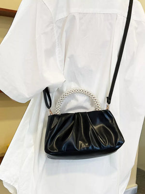 Black ruched crossbody bag with pearl handle and strap