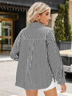 Black and white striped oversized shirt with buttoned cuffs and a collared neckline.