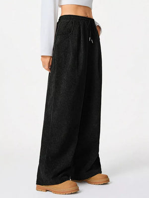 Black corduroy maternity trousers with wide legs and drawstring waist.