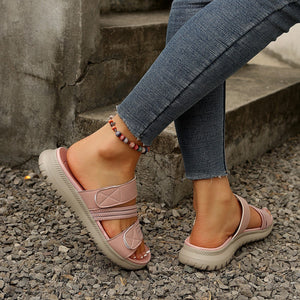 Pink multi-strap sandals with adjustable closure and cushioned sole.