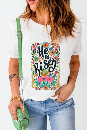 White t-shirt with embroidered floral verse "He is Risen" and Luke 24:6-7 scripture.