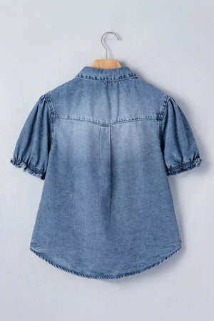 Denim shirt with short ruffled sleeves and snap closure, hanging on a hanger.