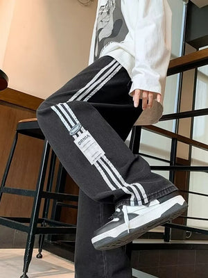 Men's black oversized wide-leg jeans with white side stripes and a casual fit.
