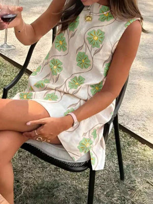 Delicate floral mini dress in cream with green flowers, high neckline, sleeveless, above the knee.