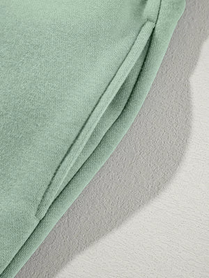 Sage cotton joggers with a side pocket detail.