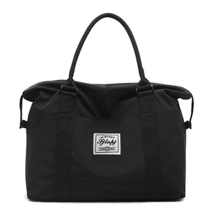 Black large capacity travel duffel bag with top handles and a front label.