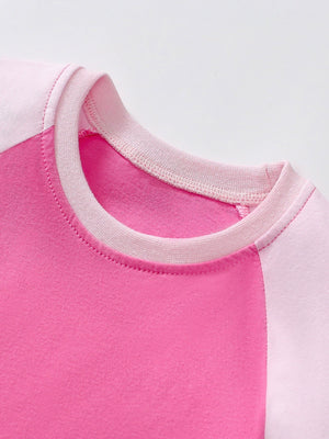 Toddler dress with pink and light pink raglan sleeves and crew neck.