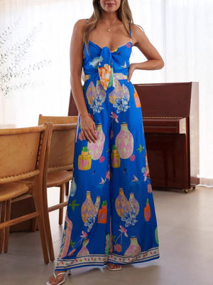 Blue wide-leg jumpsuit with tie-front and architectural print.