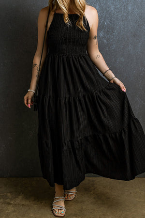 Black tiered maxi dress with textured smocked bodice and square neckline.