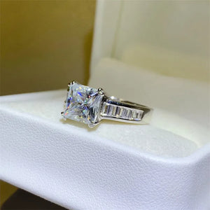 Princess cut diamond ring with baguette band in silver.