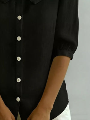 Black button-down shirt with Peter Pan collar and puff sleeves.