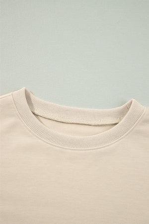 Cream sweatshirt with ribbed crew neck and visible stitching detail.
