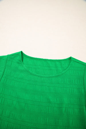 Green crew neck blouse with textured fabric and ruffle sleeves