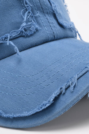 Cobalt blue denim baseball cap with raw distressed edges and visible stitching.