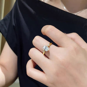 Gold moissanite ring with oval center stone and accent stones on sterling silver band