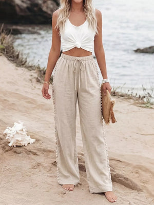 Relaxed beige drawstring wide-leg trousers with decorative side trim.