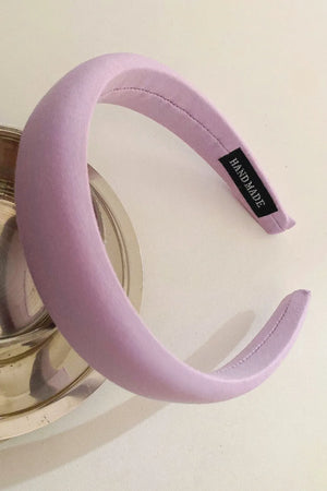 Lilac padded headband with textured fabric and a black "Handmade" tag.
