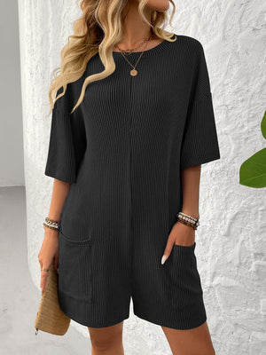 Black ribbed knit romper with short sleeves, crew neck, and front pockets.