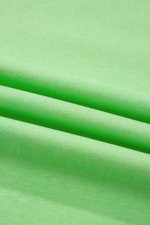 Green cotton two-piece set with pants, showing fabric texture and folds.