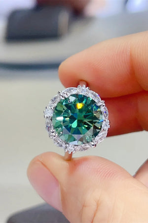 Emerald halo sterling silver cocktail ring with dark green center stone and clear accent stones.