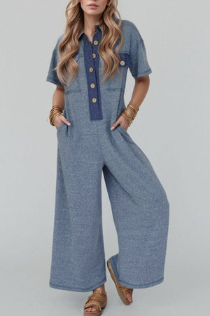 Denim-trimmed dusty blue wide-leg utility jumpsuit with button front and short sleeves.