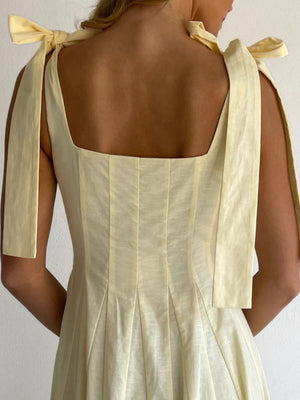 Yellow maxi dress with bow-tie shoulder straps and square neckline.
