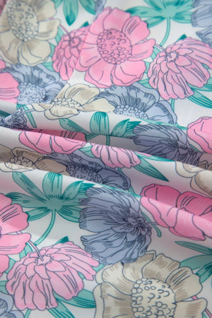 Floral print mini dress with pink, blue, and cream flowers on white fabric.