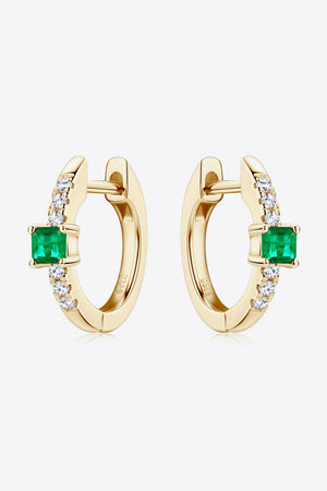 Gold huggie hoop earrings with emerald square and pave diamond details.