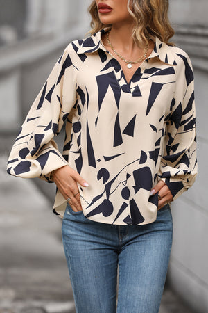 Cream geometric print blouse with voluminous sleeves and a V-neck collar.