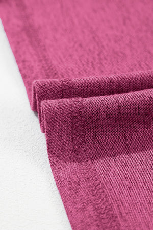 Hot pink ribbed tee with rolled cuff detail and visible stitching.